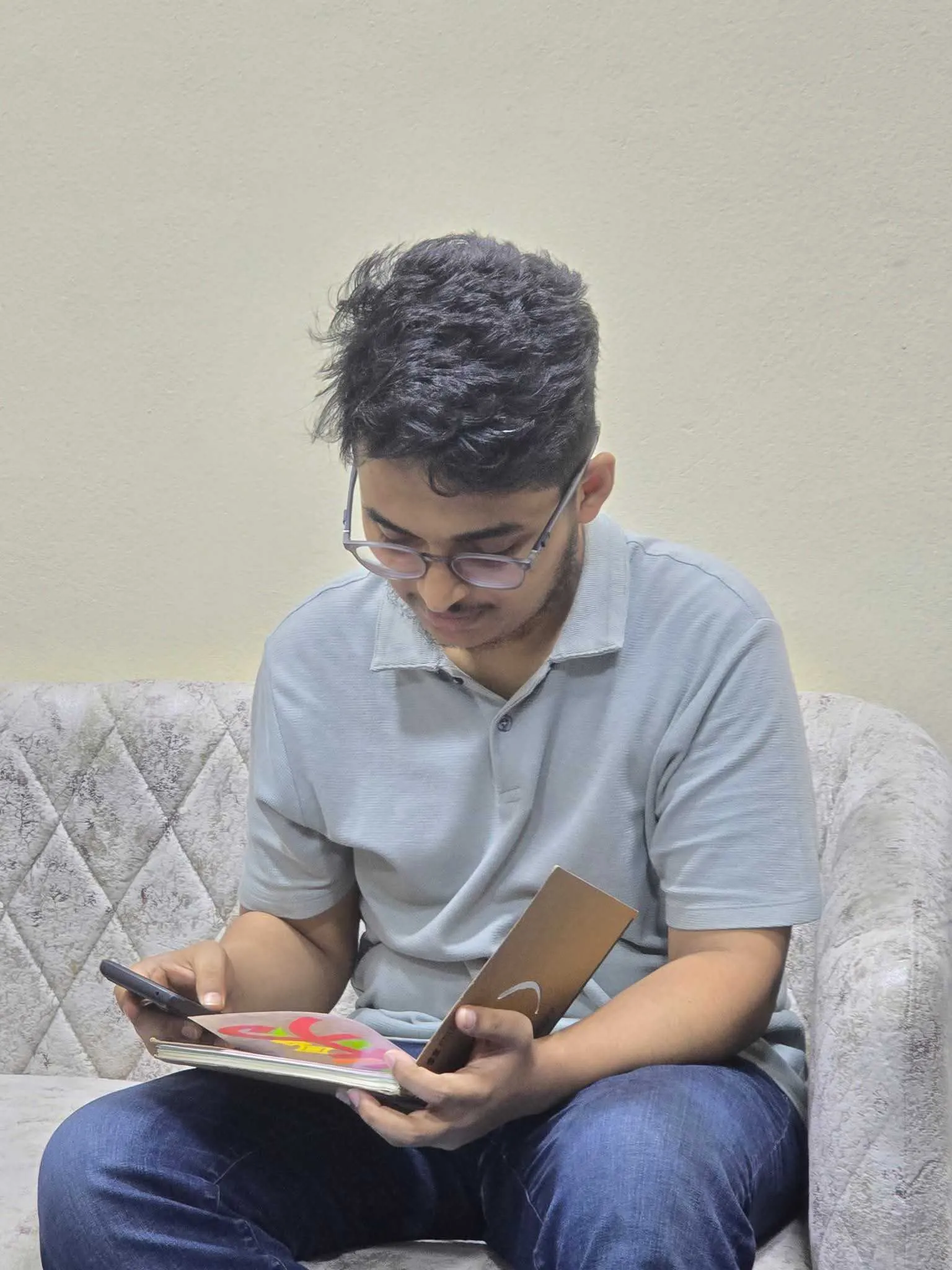 A team member reading from a tablet on the office sofa.
