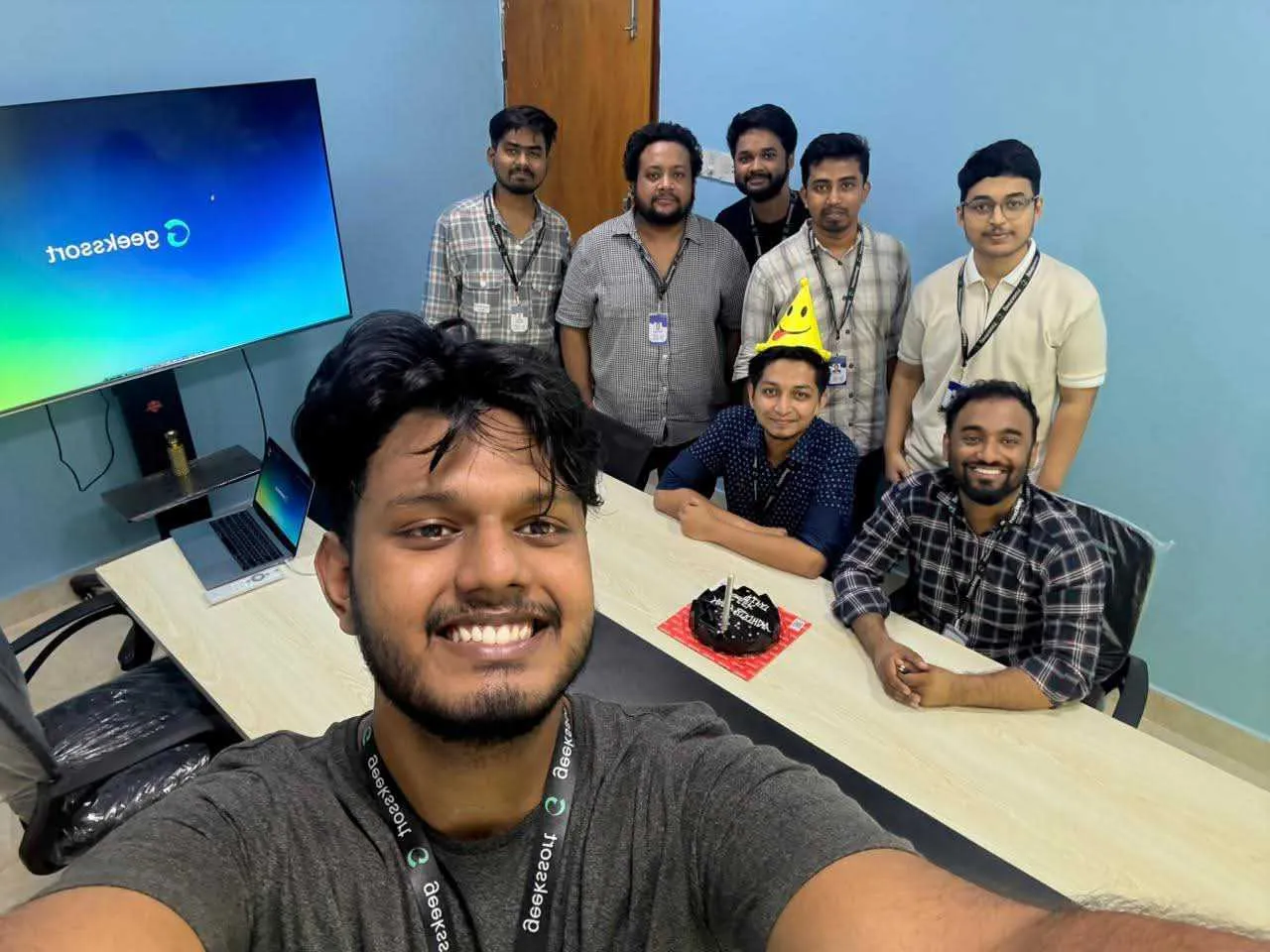 The wider team crowded into one desk for a group photo.